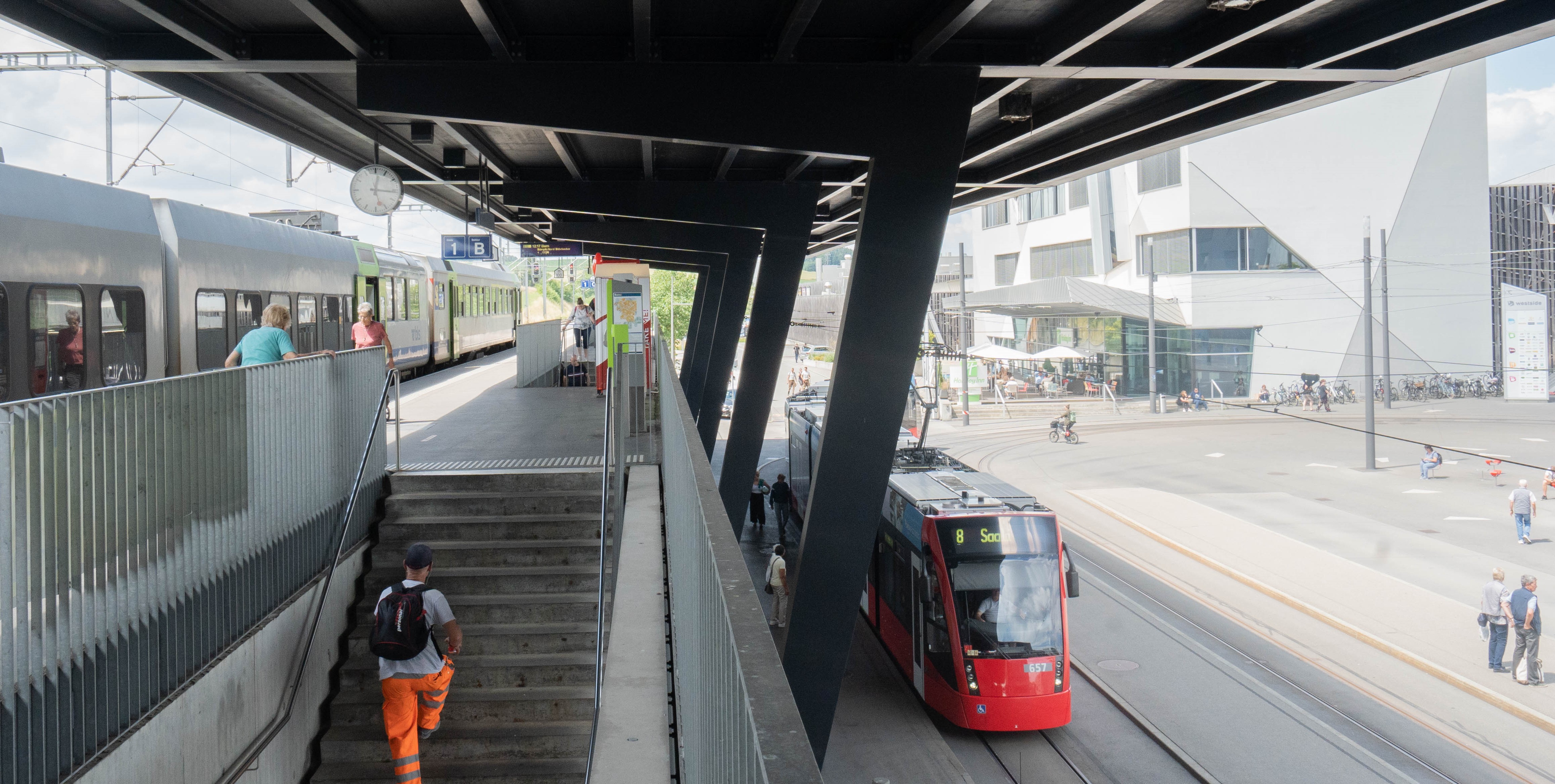 Bild des Bahnhofs Brünnen mit Zug und Tram